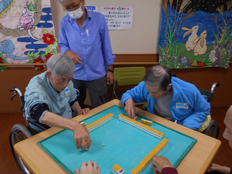 介護施設での入居者によるレクリエーション活動。スタッフが見守る中、ゲームを楽しむ様子。